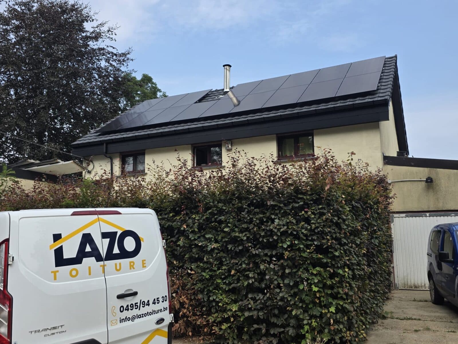 Installation photovoltaïque Lazo achevée sur une toiture en tuiles, camionnette de l'entreprise devant la maison